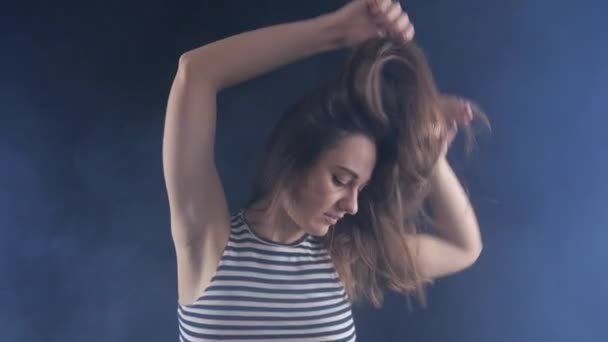 Attraktiv ung glad kvinna har kul dansa i mörkt rum. Hon viftande hår. — Stockvideo