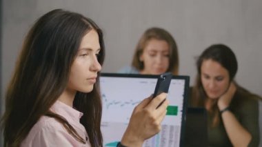 arka planda bir kız yakın çekim portresi. Neşeli grup yaratıcı serbest iş ihalekazandı. Yaratıcı iş ekibi başarı ve el çırpma sahiptir. Kız telefonu alkışlıyor. 4k