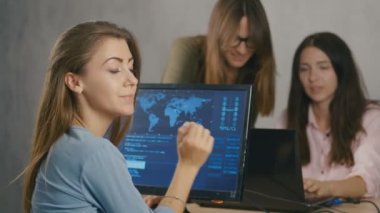 Yakın - açık saçlı bir kızın portresi. Yoğun bir iş günü. Ofiste ofis masasında birlikte otururken işlerine konsantre genç iş adamları ekibi grubu.