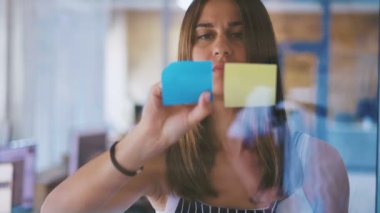 Modern ofiste cam renkli yapışkan notlar ekleyerek güzel kadın yönetici nin ön görünümü yakın