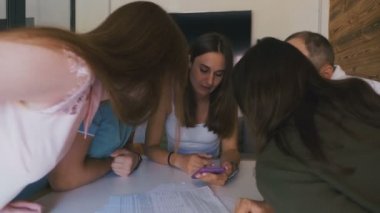Kadın takım lideri masanın yanında duran ve genç yaratıcı ekibe yön veriyor. Çok ırklı grubun beyin fırtınası. 4k