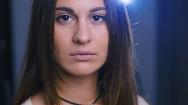 Çekici, esmer, kendine güvenen bir kadının portresi.