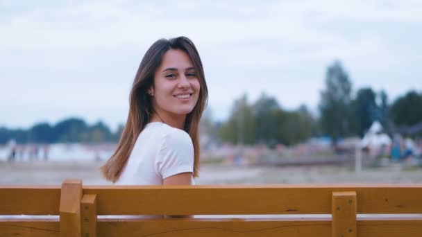 Hermosa chica sonriente sola en el fondo del lago — Vídeos de Stock