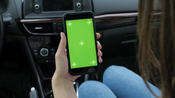 Femme utilise un téléphone avec un fond vert assis dans une voiture — Video