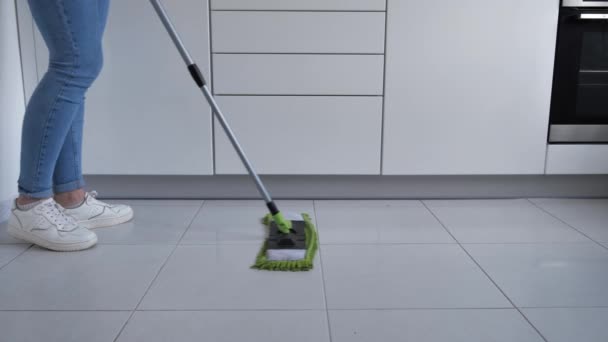 妇女用特殊的刷子清洗厨房的白色地板、清洁服务、特写 — 图库视频影像