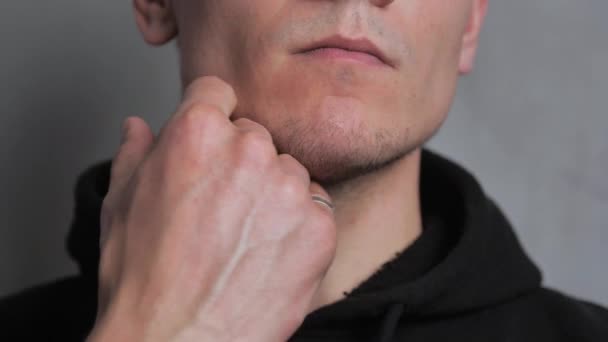 Irritation cutanée après le rasage. L'homme frotte sa main sur son menton gros plan . — Video