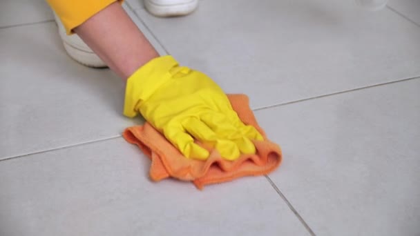Νοικοκυρά γυναίκα σε κίτρινα γάντια πλύνετε το πάτωμα με κουρέλι πορτοκαλί — Αρχείο Βίντεο