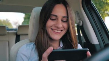 Sürücü kız gündüz vakti cep telefonuna bakıyor.