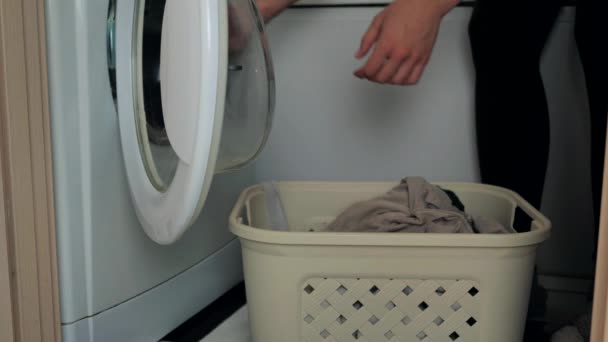 Mujer poniendo ropa sucia en la lavadora tambor y conmutación — Vídeos de Stock