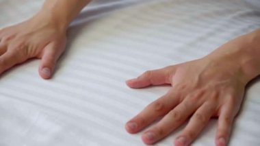 Ev işi, ev işi ve temizlik konsepti. Yatak çarşafı yapan kadının elleri.