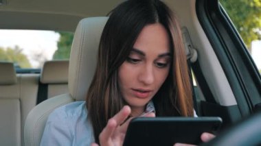 Sürücü kız gündüz vakti cep telefonuna bakıyor ve gülümsüyor.