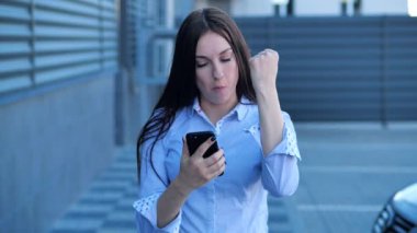 Telefonu elinde tutan mutlu kız iyi haberi kutluyor 4K