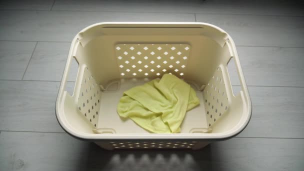 Lanzar ropa sucia de color en la cesta de la ropa — Vídeo de stock