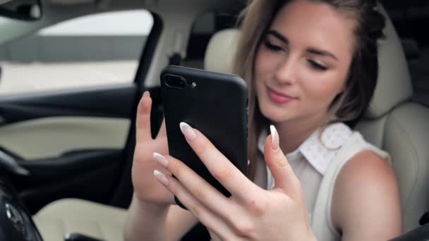 Close-up vinger zicht van een jonge blanke vrouw met behulp van smartphone surfen flipping nieuws Internet in de auto op parking 4k — Stockvideo