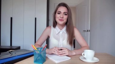 Genç esmer kadının internet üzerinden iş görüşmesi var. Başını sallar, dinler, sessiz kalır, gülümser. Web kamerası görünümü 4k