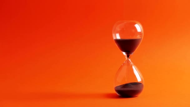 SAND-GLASS, Sanduhr schwarz auf orange Bildschirmhintergrund 4k — Stockvideo