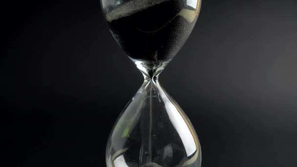 Horloge en verre de sable gros plan sur fond noir. Concept de temps — Video