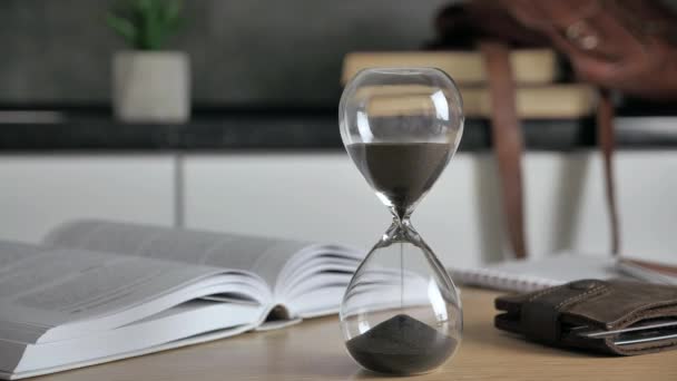 Время иссякло. Песочные часы на деревянном столе Сэндс перемещается через часовое стекло. 4k — стоковое видео