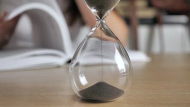 Kum saatine kum dökerek bir ahşap masaya 4k.