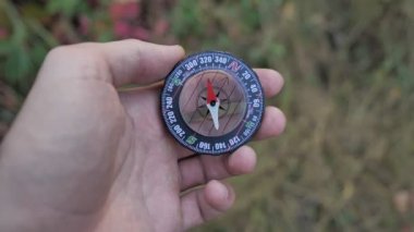 Erkek bir turist, 4k ormanındayken elinde cam pusula tutuyor.