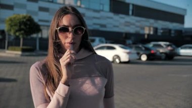 Güzel, genç bir hipster kadını kapatıyoruz. E-sigaralı mutlu esmer vaper kızı. Sigara içen kadın modelin elektronik sigarayla portresi.