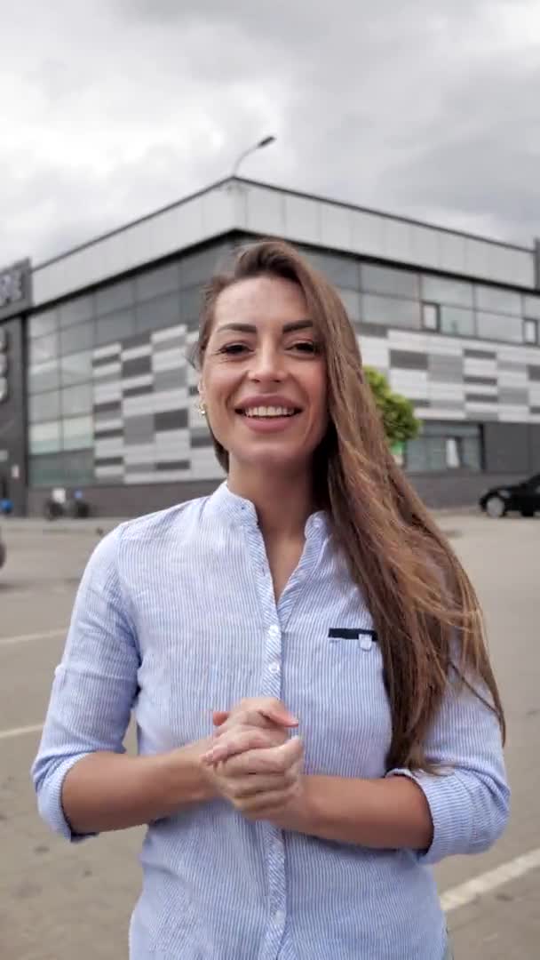 Mujer hablando con amigos en línea, blogueando, saludando con la mano, riendo cerca del estacionamiento. Punto de vista de la cámara 4k — Vídeos de Stock