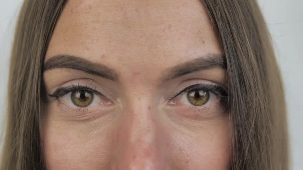 Potret tertutup wajah perempuan muda yang cantik dan Kaukasia dengan mata hijau yang indah dengan penuh perhatian melihat ke kamera — Stok Video