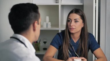 Kadın ve erkek doktorlar klinikte iletişim kuruyor, terapist ve cerrah