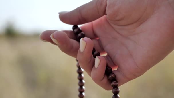 Meditación sobre rosario de madera, primer plano, macro. Panorámica. Religión, esperanza, concepto de amor. En cámara lenta. 4k — Vídeo de stock