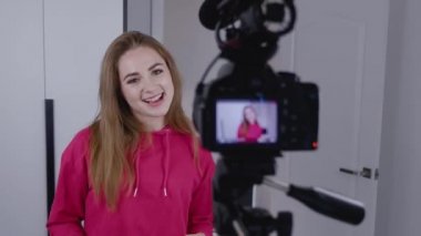 Mutlu genç bayan blogger vlogger video blogcusu video blogu yapıyor. Kamerayla konuşuyor. Evdeki kameraya bakıyor, viderecord ve sosyal medya vlog kavramına bakıyor..