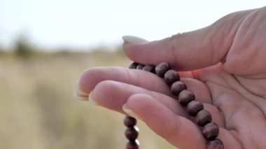 Tahta tespih, yakın çekim, makro üzerine meditasyon. Çeviriyorum. Din, umut, aşk konsepti. Ağır çekim. 4k