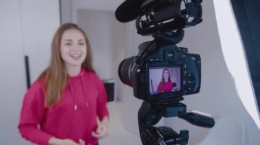 Genç ve mutlu bayan blogger vlogger blogcusu vlog blogu yapıyor kamerayla konuşuyor evdeki kameraya bakıyor, viderecord ve sosyal medya vloglama kavramına bakıyor. 4k