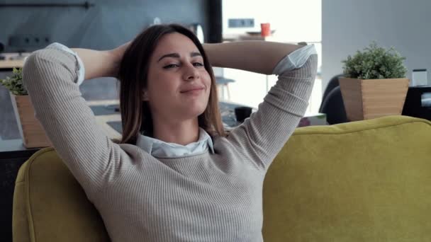 Serena jovem mulher descansando no sofá de mãos dadas atrás da cabeça tomando respiração profunda de ar fresco. — Vídeo de Stock