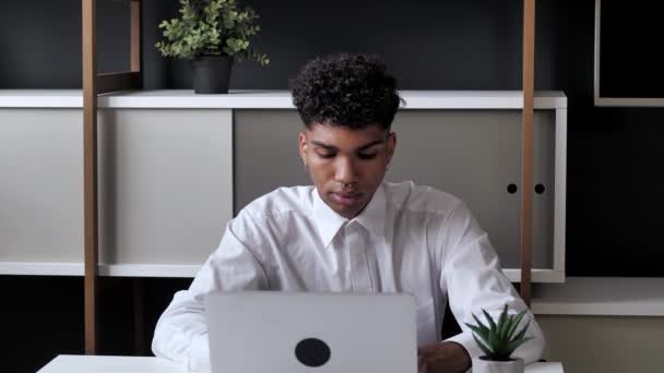 Casual afro-américain étudiant entrepreneur concentré développement nouveau projet tout en travaillant sur ordinateur portable au bureau moderne. 4k — Video