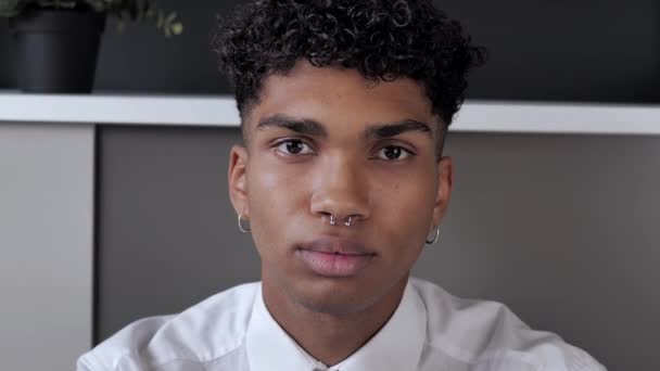 Kendine güvenen genç siyahi bir stajyerin portresi kameraya ciddi bakıyor ve ofisteki bağımsız Afro-Amerikan erkeği gülümsüyor. — Stok video