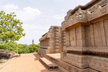Arkasında ağaç olan taş bir bina. Bina eski ve çok detay içeriyor.
