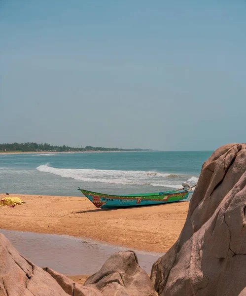 Okyanusun yakınındaki sahilde bir tekne oturuyor. Gökyüzü açık ve su sakin.