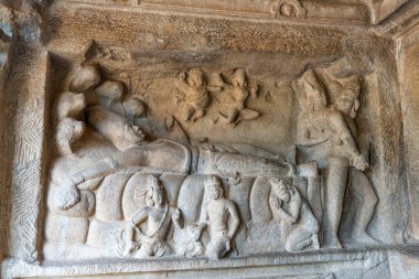 Kılıç tutan bir adam ve omzunda eli olan bir kadının taş oyması. Oyma bir öykü ya da efsaneden bir sahne.