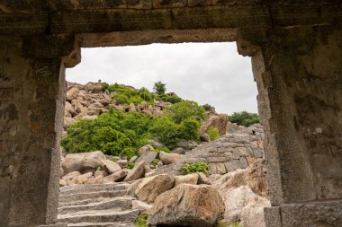 Dağ manzaralı taş bir kemer. Kemer yolu açık ve dağ ağaçlarla kaplı. Tamil Nadu.