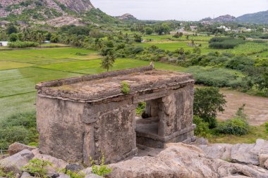 Yan tarafında pencere olan küçük bir bina. Bina taştan yapılmıştır. Pencere açık. Tamil Nadu.