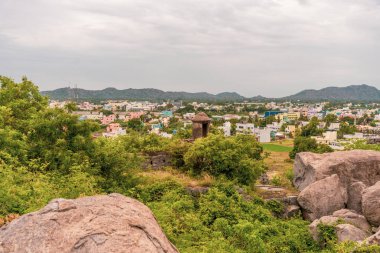 Uzakta bir şehir olan bir dağ sırası. Şehir evler ve binalarla dolu. Dağ sırası ağaçlarla kaplı. Tamil Nadu.