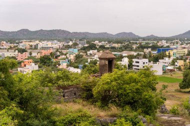 Arkasında dağ olan bir şehir. Şehir evler ve binalarla dolu. Kentin ortasında büyük bir bina var. Tamil Nadu.