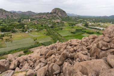 Vadi manzaralı kayalık bir yamaç. Vadi yeşil tarlalar ve evlerle dolu. Tamil Nadu.