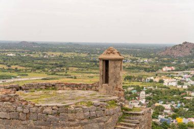 Yan tarafında pencere olan küçük bir bina. Bina bir tepenin üzerinde. Tepe bir tarla ile çevrilidir. Tamil Nadu.