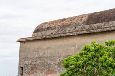 Önünde yeşil bir ağaç olan bir bina. Ağaç, binanın sağ tarafındadır. Tamil Nadu.