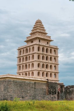 Tepesinde kule olan yüksek bir bina. Bina taştan yapılmıştır. Gökyüzü bulutlu. Tamil Nadu.