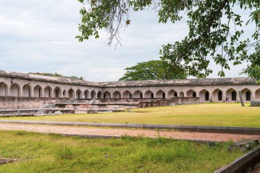 Ortasında çimen olan büyük bir avlu. Arka planda birkaç bina var. Tamil Nadu.