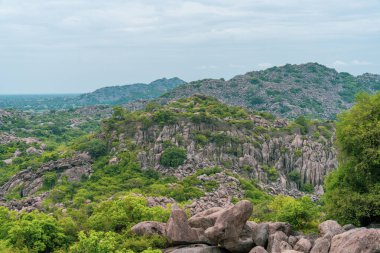 Tepesinde orman olan bir dağ sırası. Ağaçlar yeşil ve gökyüzü mavi. Dağlar çok yüksek ve ağaçlar yayılmış. Tamil Nadu.