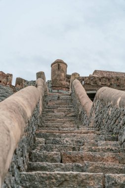 Bir binaya çıkan taş bir merdiven. Basamaklar taştan yapılmış ve çok dik. Tamil Nadu.