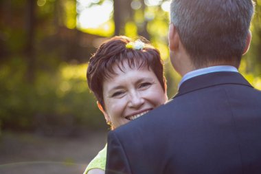 adam sırtı ile sahanın ve omzunun arkasından bir kadın bakıyor